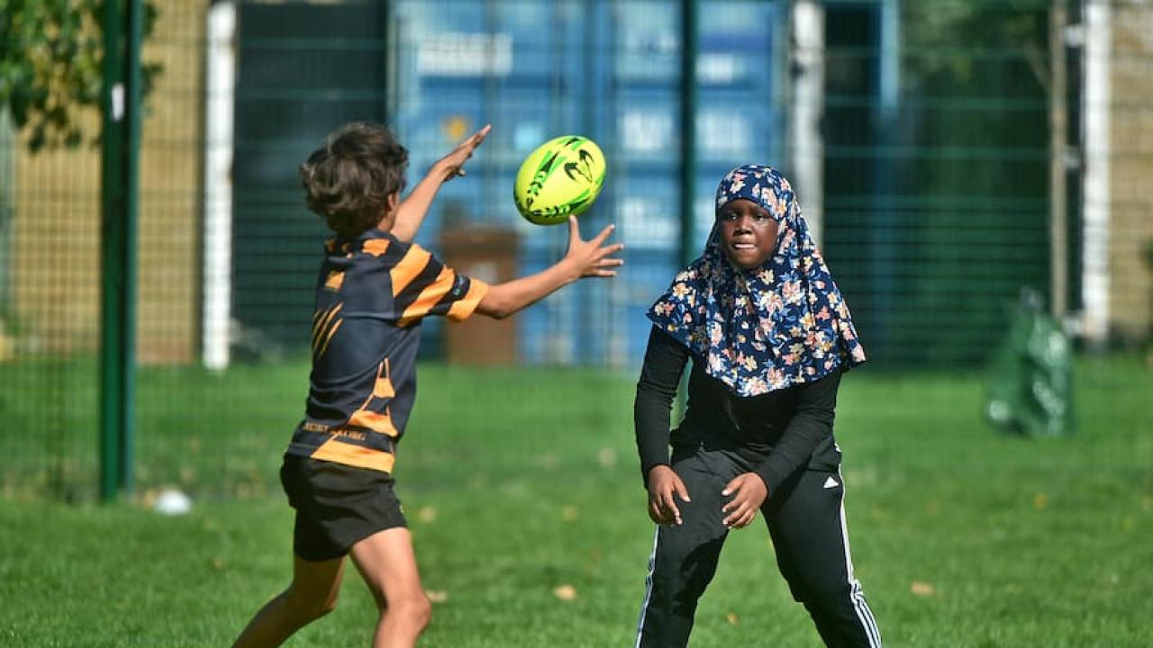 Girl in hijab playing rugby