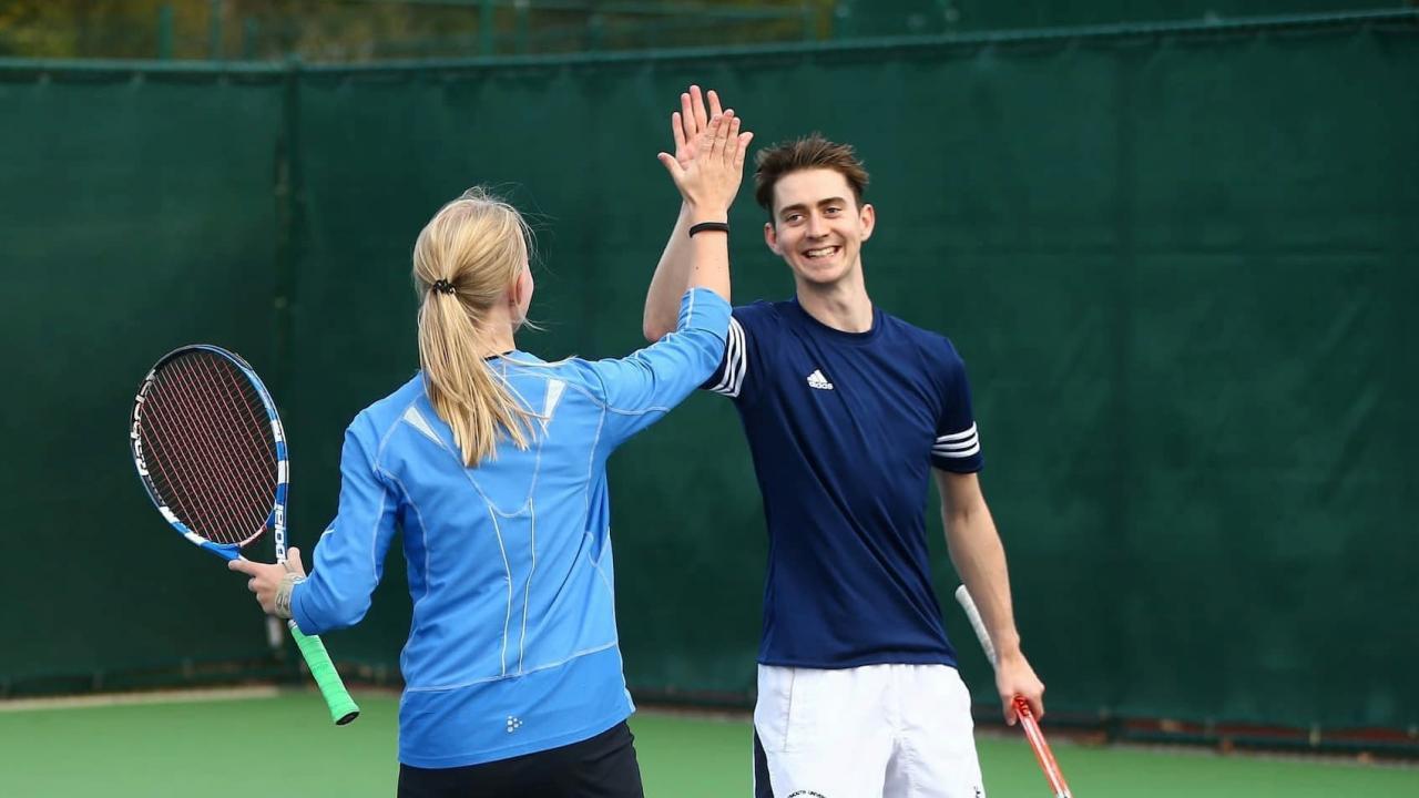 Mixed doubles partners high fiving