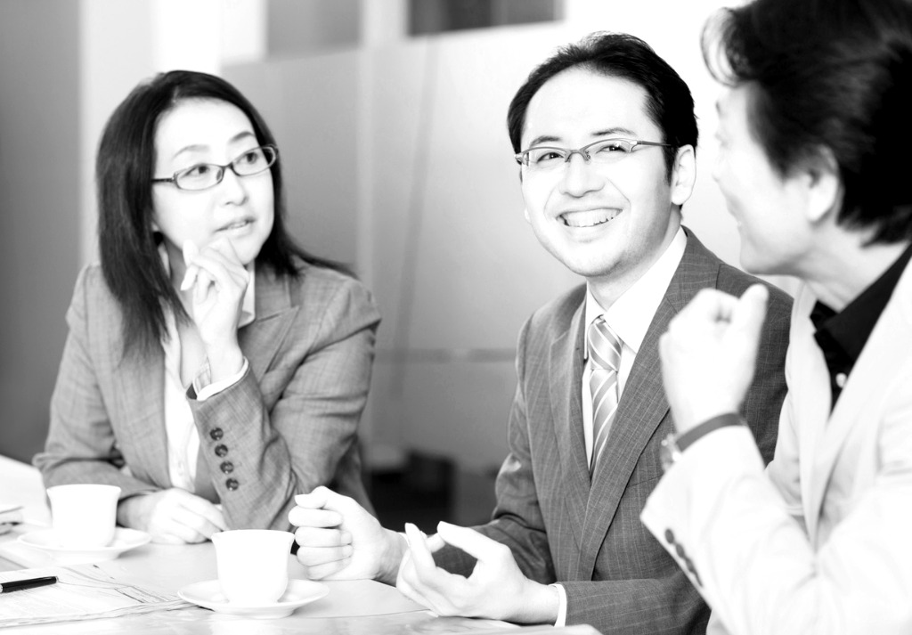 1 Asian woman 2 Asian men discussing business
