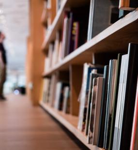 Blurred man looking at library shelves