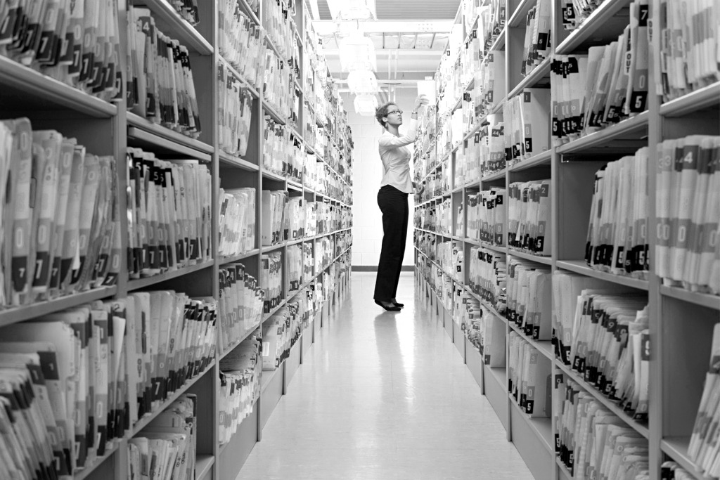Woman looking through shelves of paperwork records