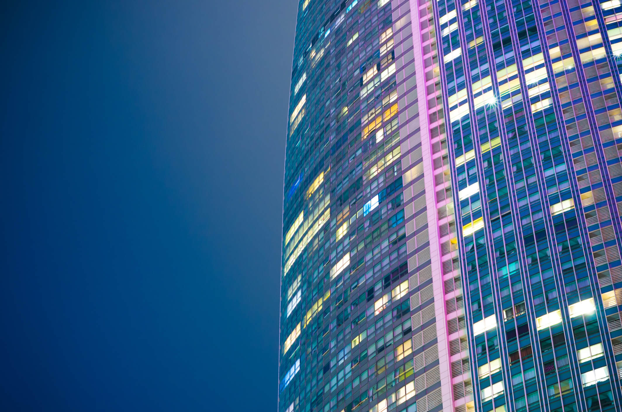 A modern tower block lit up at night