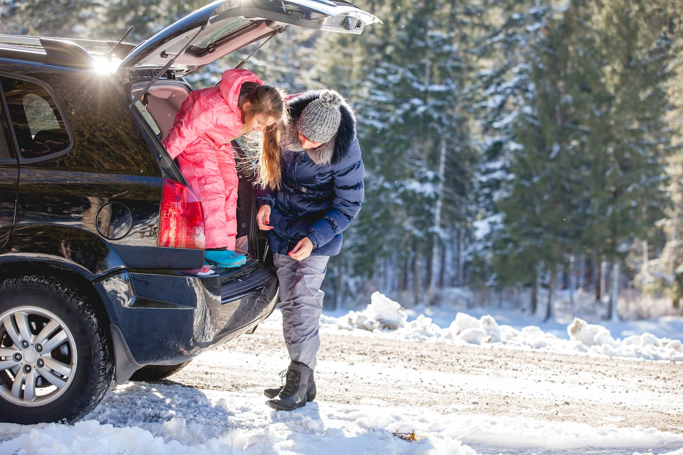 rodzina wyskakuje z samochodu na śniegu