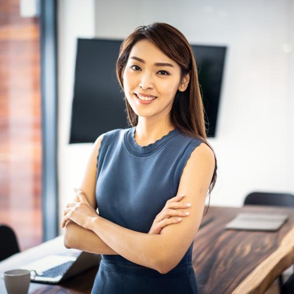 A confident business woman smiles with her arms folded