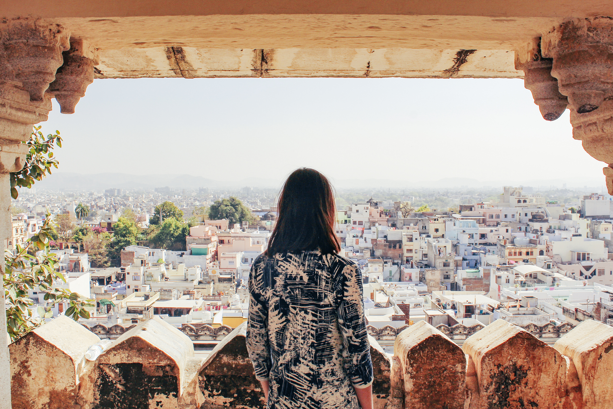 A woman looks out at the view of Udaipur, Rajasthan