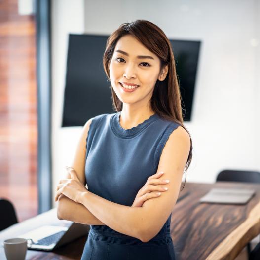 A confident business woman smiles with her arms folded