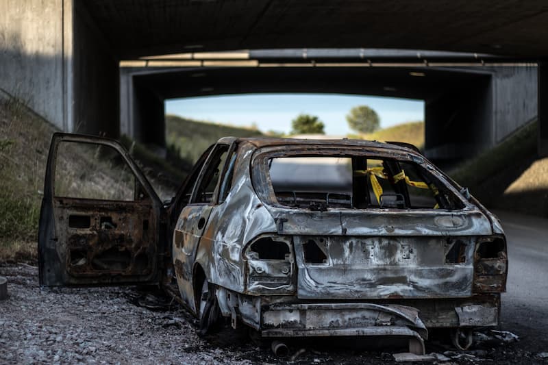 a burnt out car on the side of the road