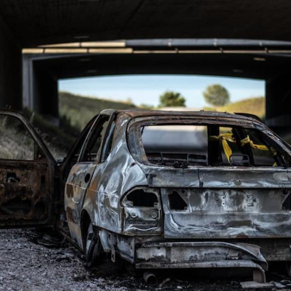 a burnt out car on the side of the road