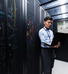 man looking at server room assessing cyber risks