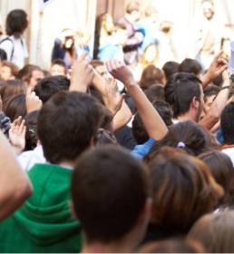 Image of a very crowded place and people having their hands raised