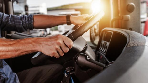 Driver at the wheel of a van at sunset