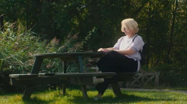 Caroline Birch at a picnic table in a nature reserve