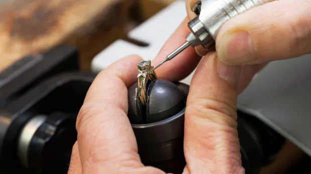 A close-up photo of a jeweller working on a beautiful luxury engagement ring
