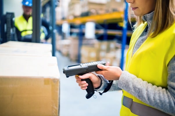 Asian warehouse worker scanning a box