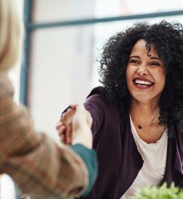 Two women chatting and shaking hands