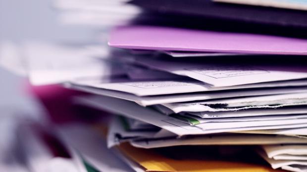 A stack of files sits on a desk