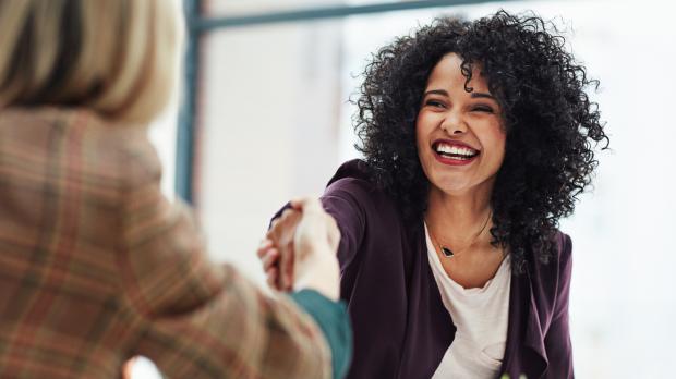 Two women chatting and shaking hands