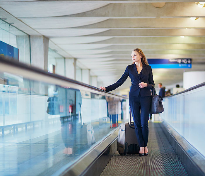 Woman in business suit on airport travelator