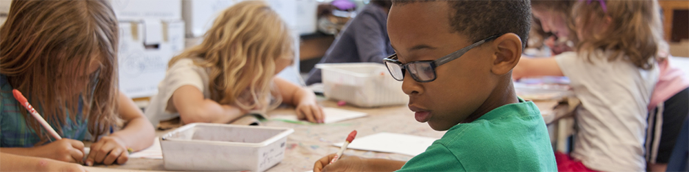 Early years classroom with children using pens and writing