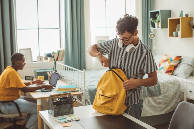 Student packing rucksack in accommodation 