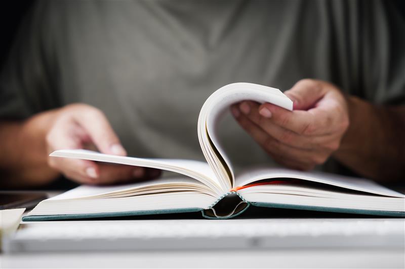 Someone holding a book and turning the pages