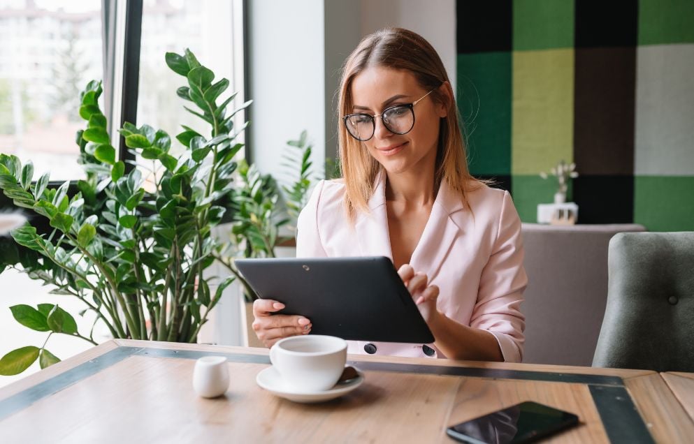business woman sitting in a coffee shop on a tablet