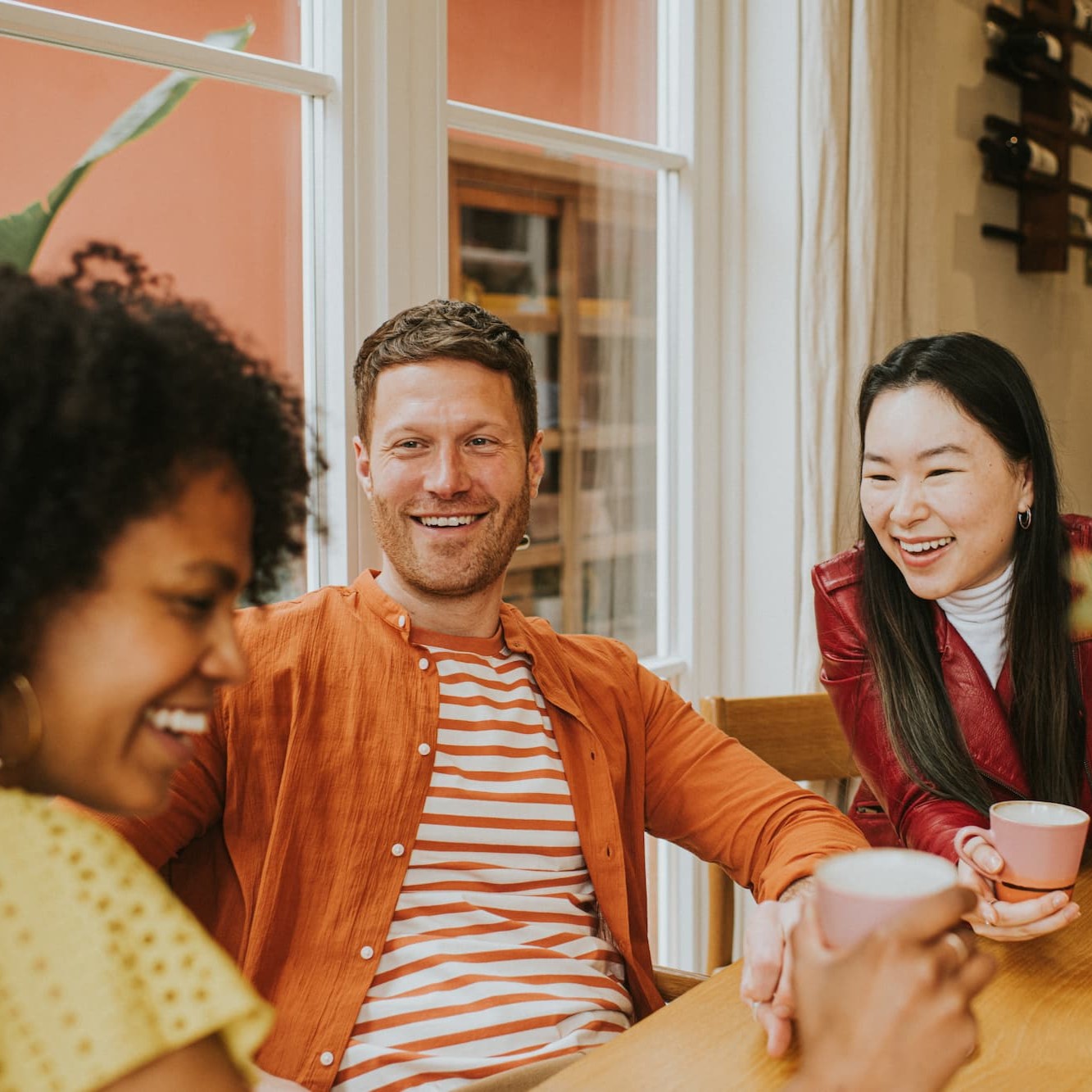 Three friends drinking coffee and smiling