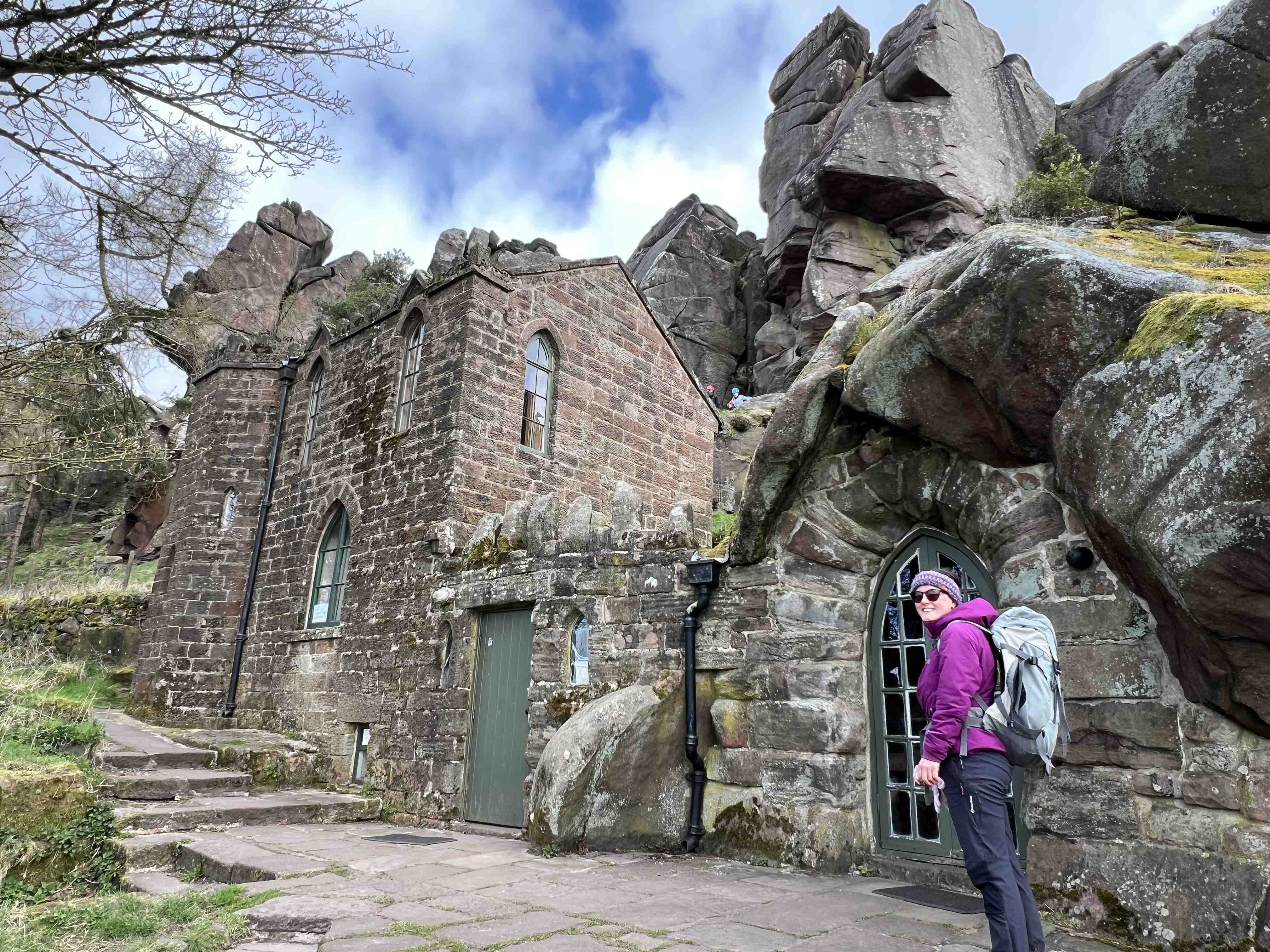 Woman in camping gear standing outside mountaineering hut