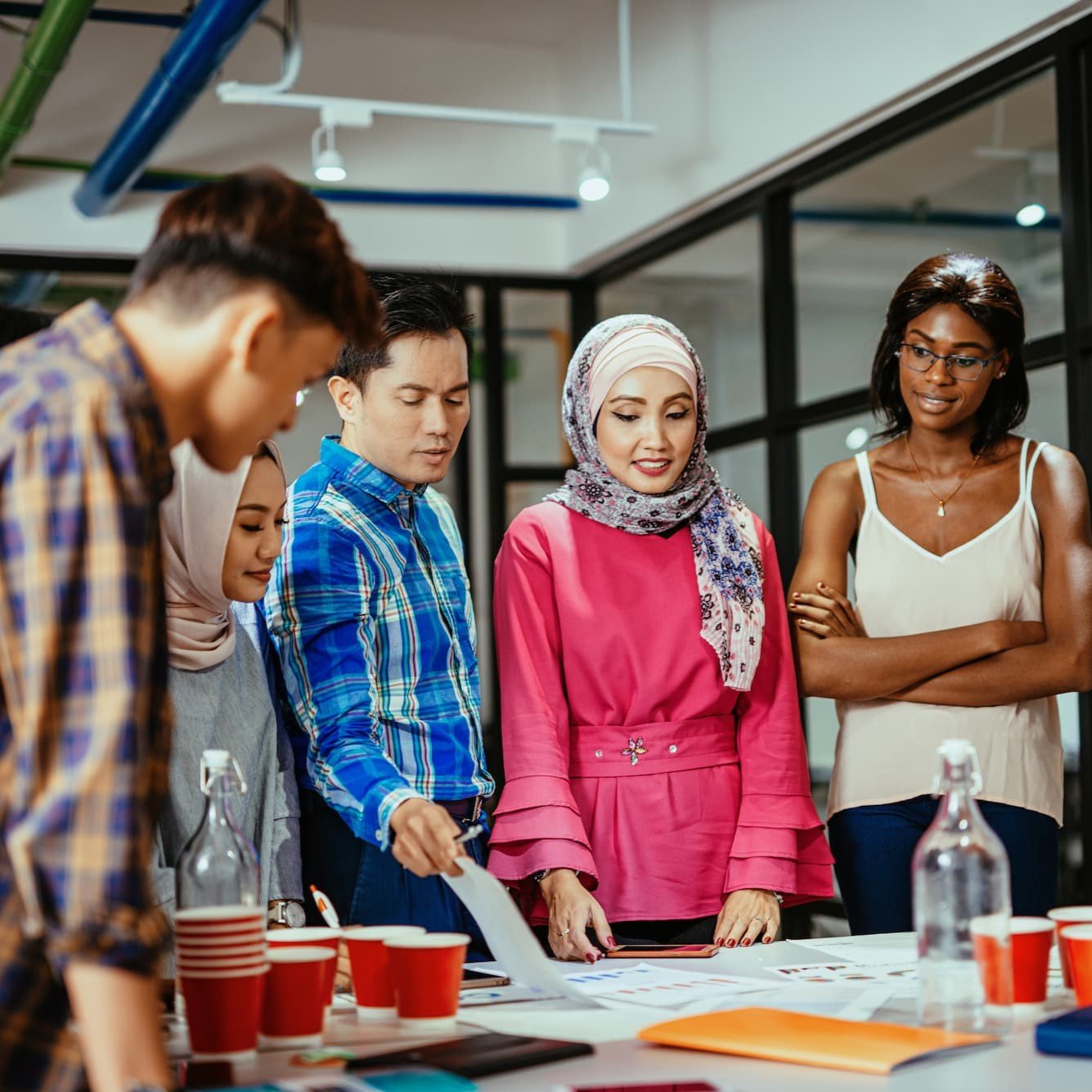 Multicultural colleagues collaborating around a shared workspace