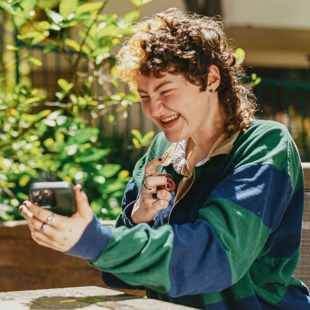 Neurodivergent woman looking at her phone and smiling