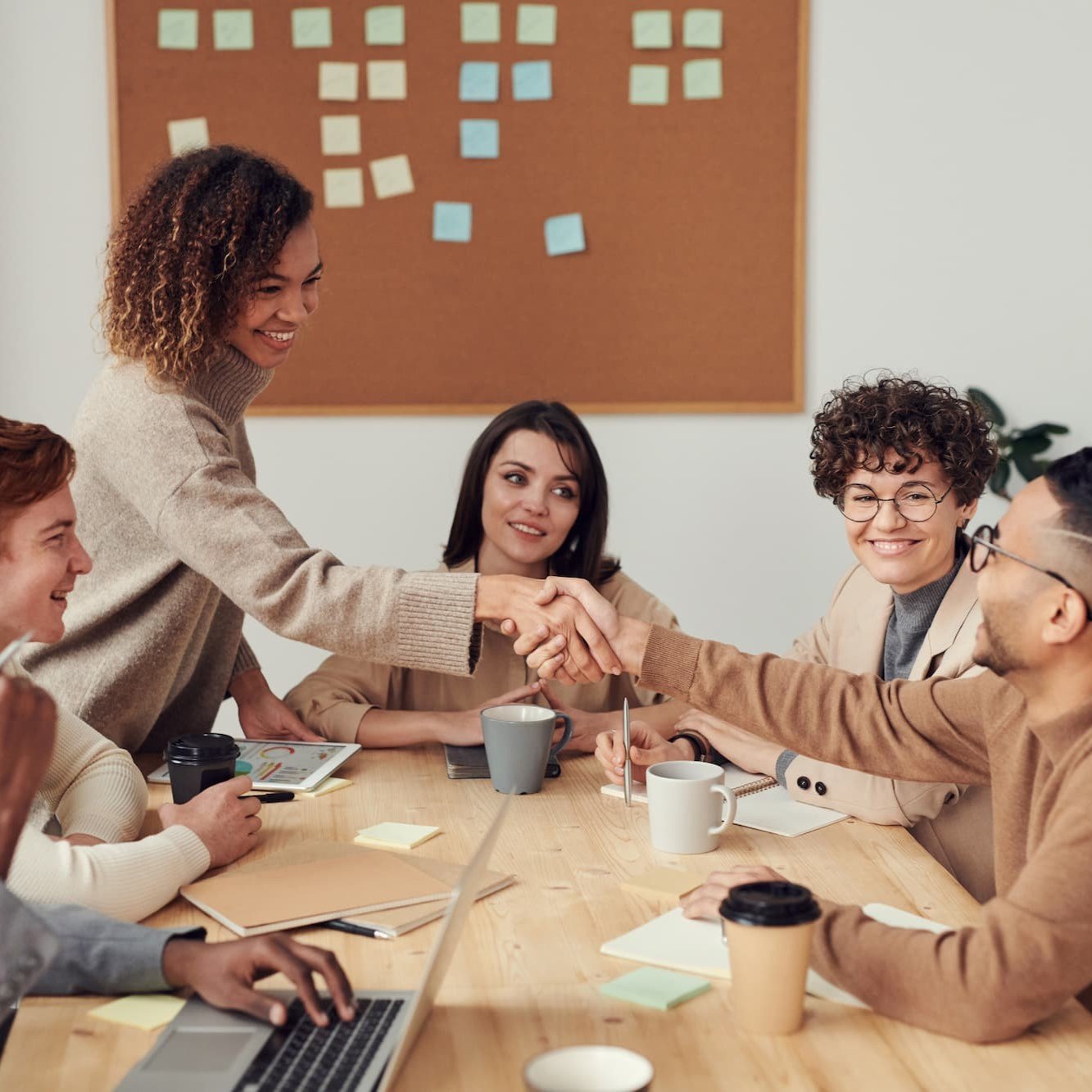 Group of under 30s sitting round a table at work