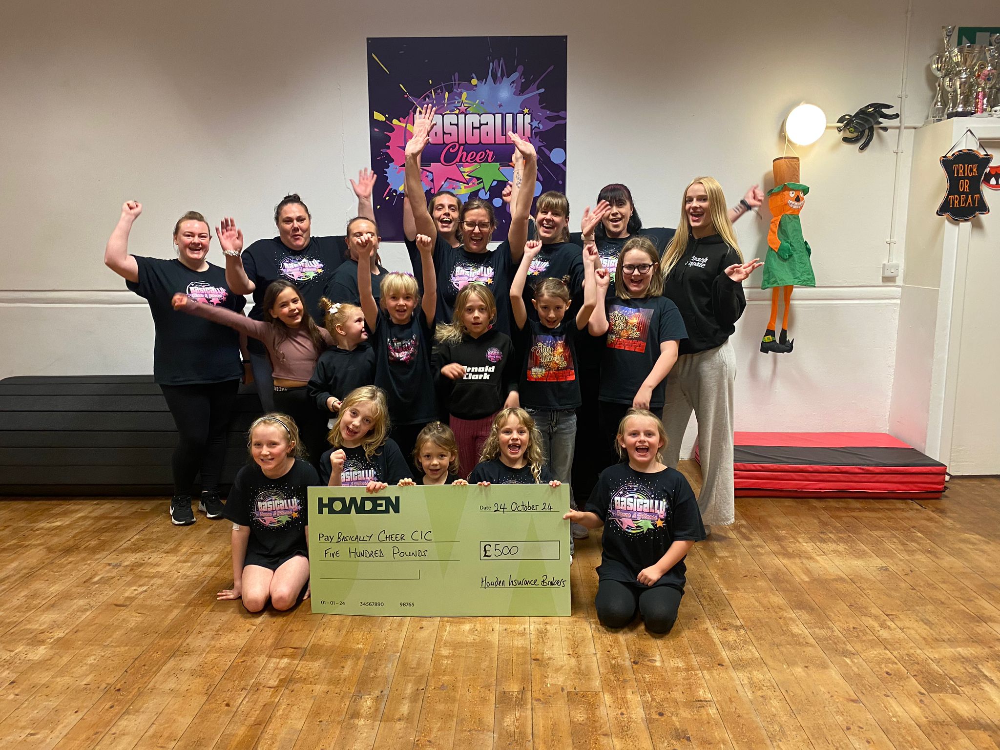 Cheerleading class celebrating their win with a giant cheque from Howden for £500 towards their club as one of our previous competition winners