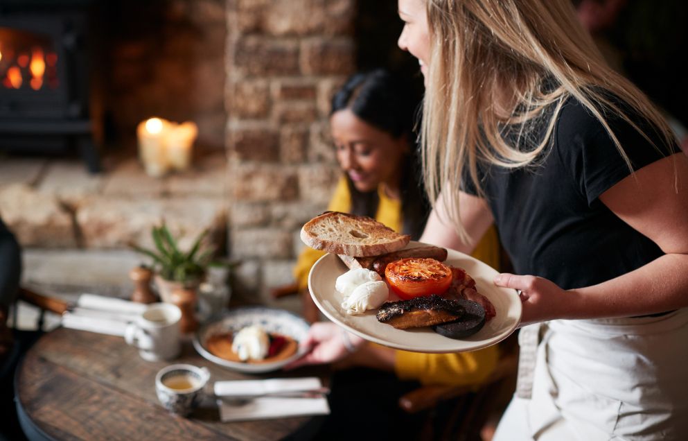 young woman serves food in restaurant