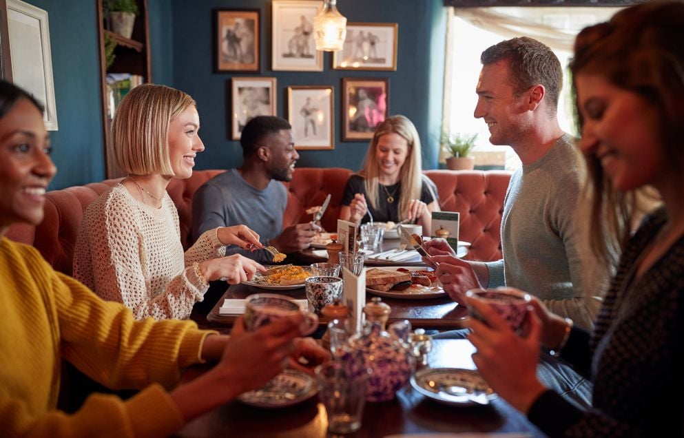 Group of people eating in restaurant of busy traditional English pub