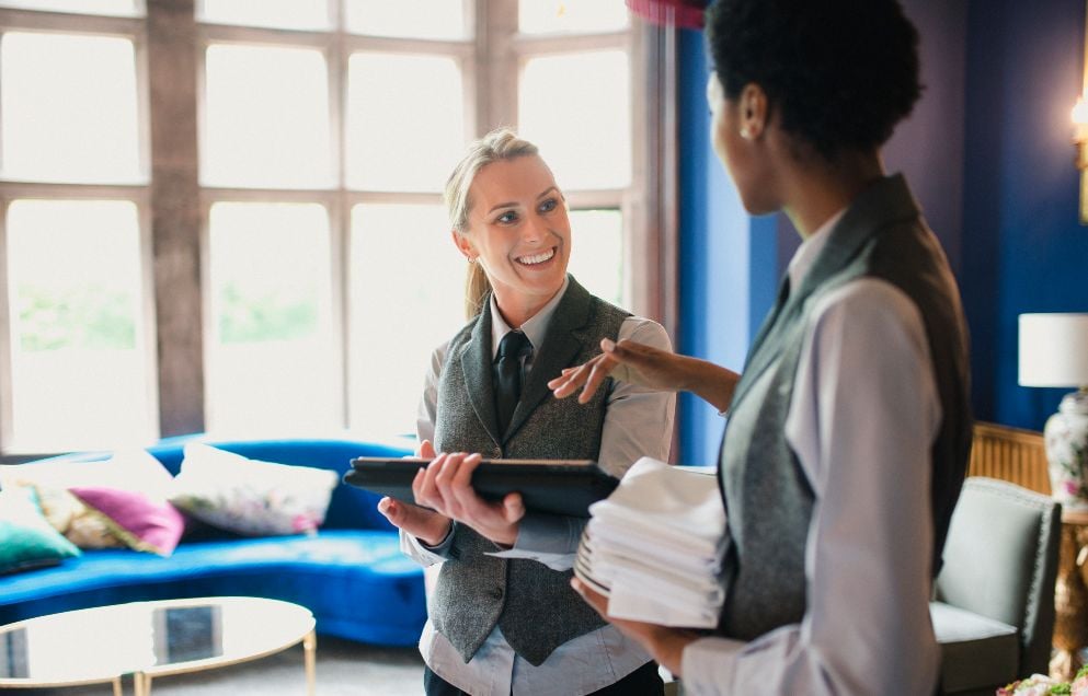 Two female hotel staff are talking and working together 
