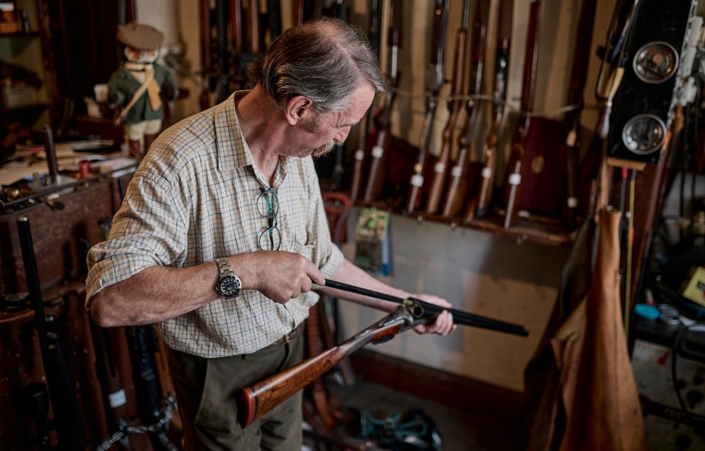 man cleaning a shotgun