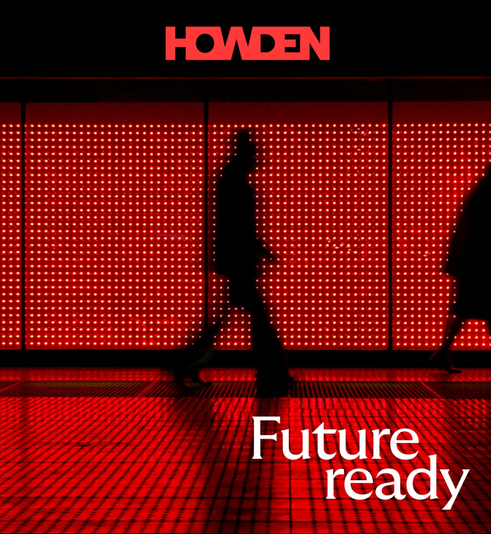 Silhouetted figures walk in front of a red illuminated wall with the words “Future ready” and “Howden” displayed.