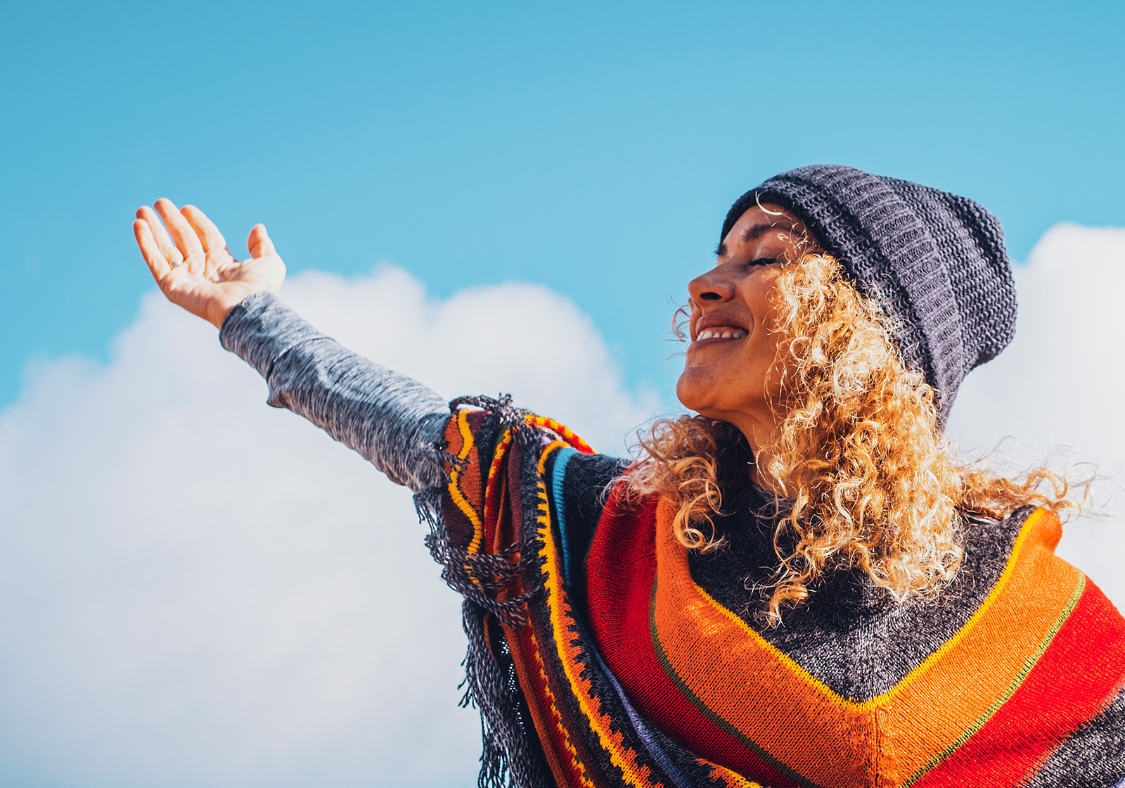 Smiling woman with her arm outstretched to the sky