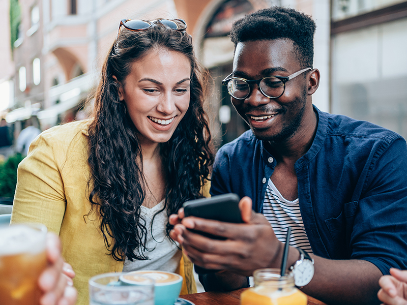 A man and a woman smiling at a phone