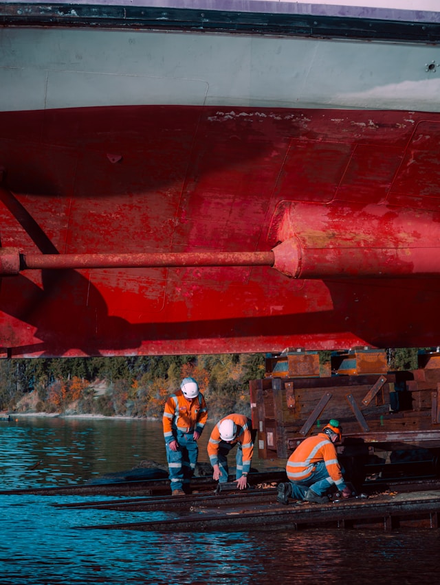 The workers inspect the underside of a ship