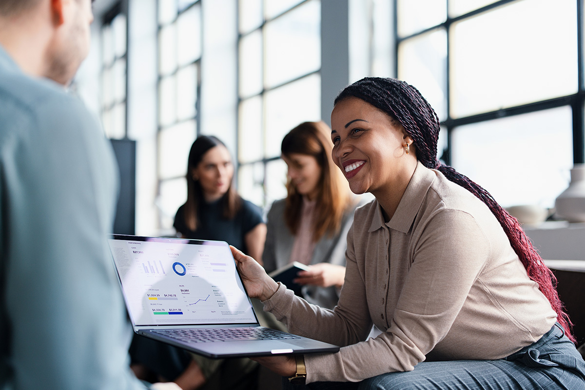 Woman presenting data on laptop to a colleague