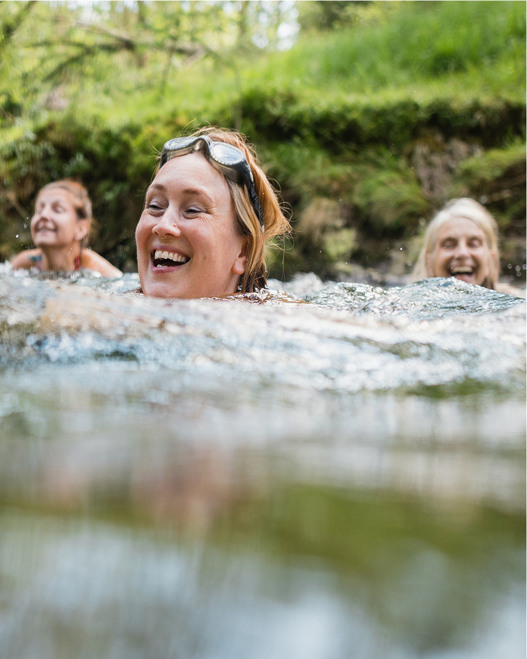 Three women swimming in a river