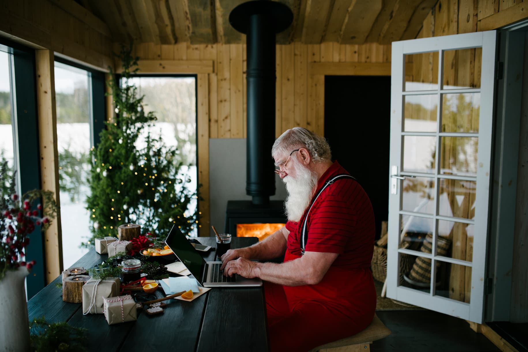Santa Claus with his hat off on his laptop doing life admin