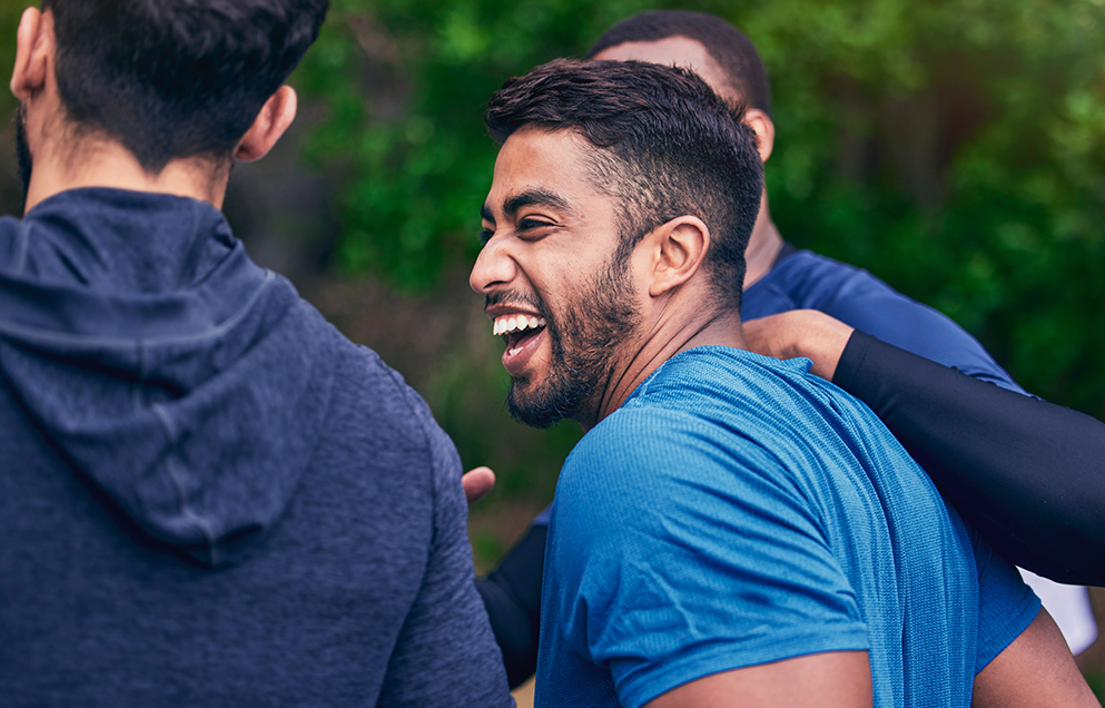 Men laughing in a park - Men's health at work