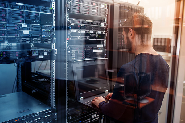 A person in a server room with laptop