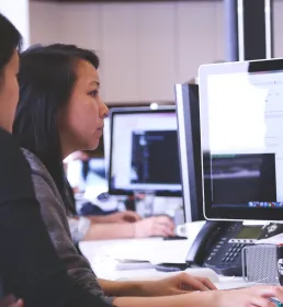 Two actuaries looking at a computer