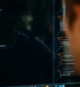 A man looking at code on a computer screen
