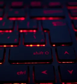 A close-up of a keyboard with red light glowing from under the keys