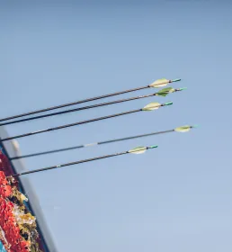 Archery arrows in target board blue sky