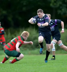 Rugby player sidestepping tackle